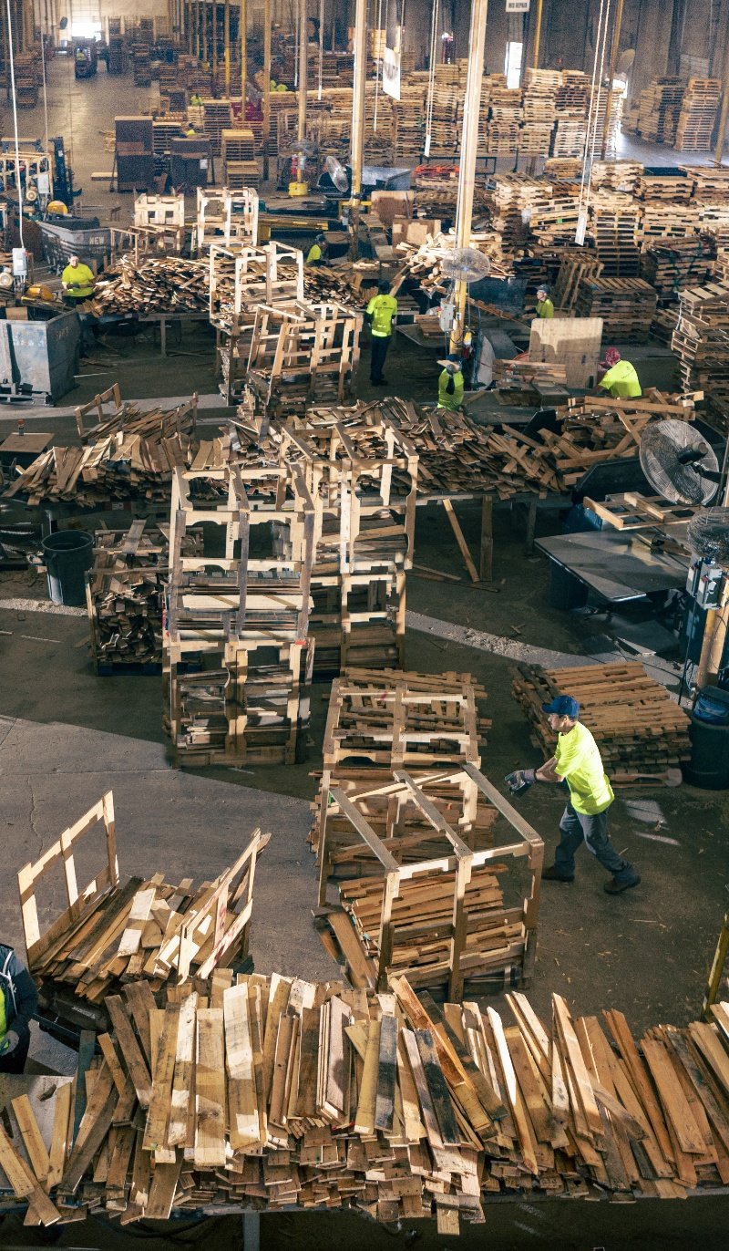 Aerial shot of people moving pallets inside a warehouse