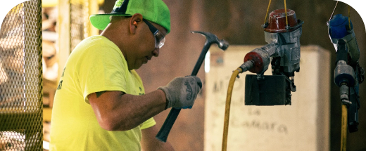 Man with hammer working on-site at a facility